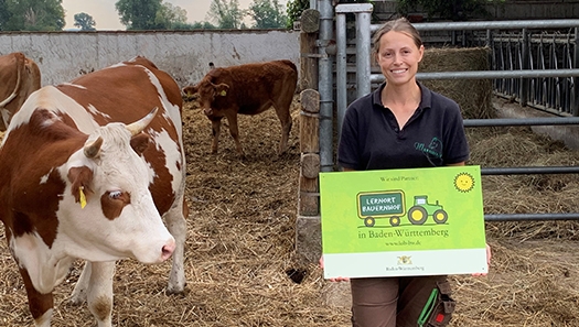 Bauernhof - Betriebsleiterin Carolin Hoffmann mit dem „Lernort Bauernhof“-Schild