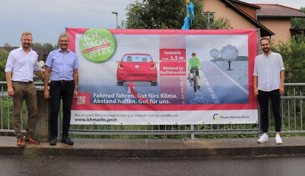 (v.l.n.r.) Dezernent Dr. Christopher Leo, Neidensteins Bürgermeister Frank Gobernatz und Ricardo Beringer von der Stabsstelle Nachhaltige Mobilität des Rhein-Neckar-Kreises präsentierten das großformatige Banner (Foto: Landratsamt Rhein-Neckar-Kreis)