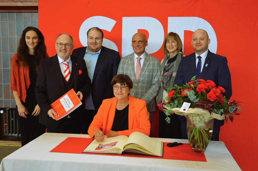 Die SPD-Parteivorsitzende Saskia Esken trägt sich ins Goldene Buch der Gemeinde ein. Anlass ist der 120. Geburtstag des SPD-Ortsvereins. Mit auf dem Bild: Vertreter*innen der örtlichen SPD und Bürgermeister Pascal Seidel. (Foto: Lukas Polifka)