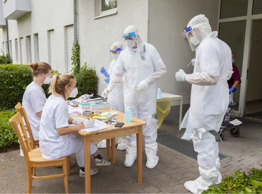 Beispielbild; Tester in Schutzanzügen vor einem Pflegeheim; Quellen: GRN/RNK