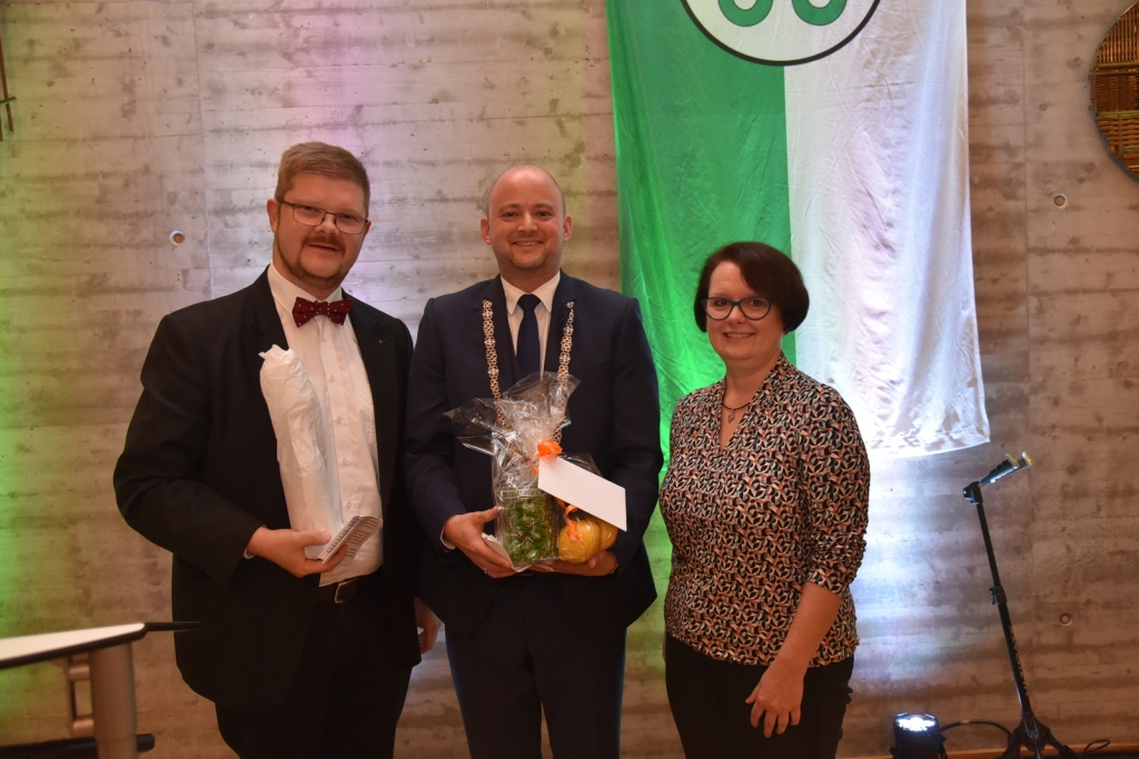 Pfarrer Tobias Habicht und Marion Kolb von der katholischen Seelsorgeeinheit überreichen Bürgermeister Seidel Geschenke.